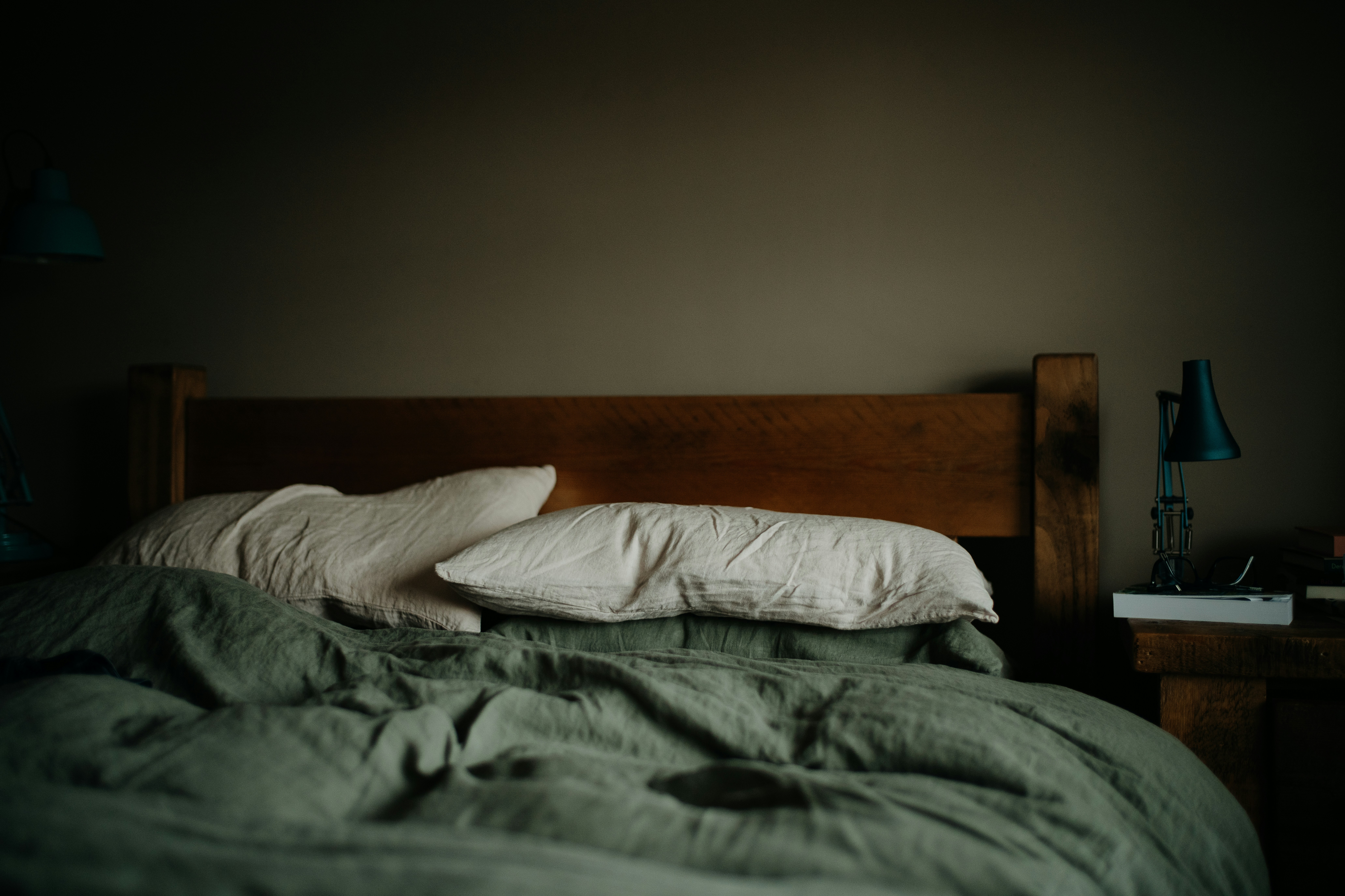 An empty bed in a dimly lit room, evoking the quiet frustration of sleepless nights