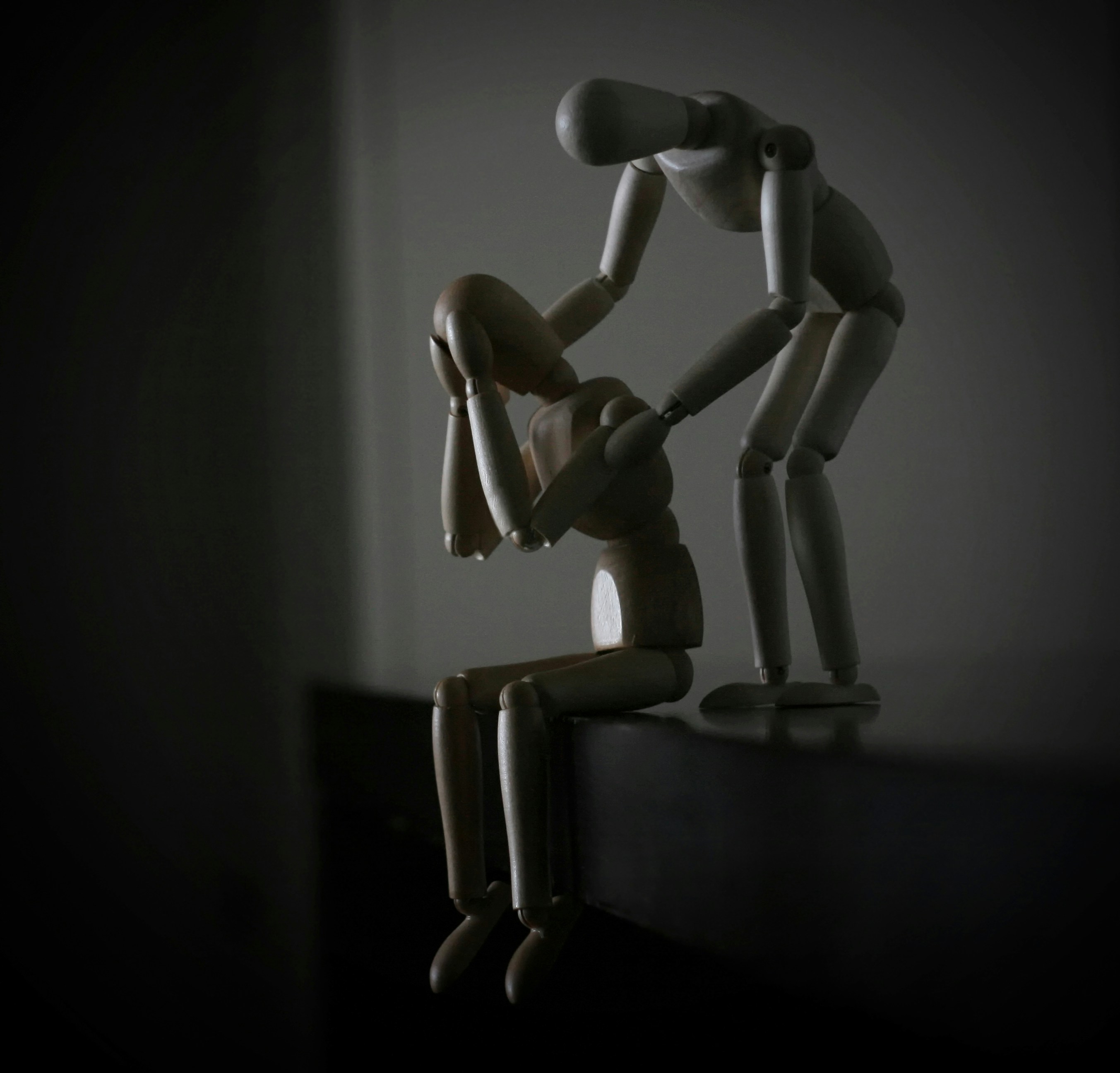 One figure comforting another, representing the supportive nature of therapy