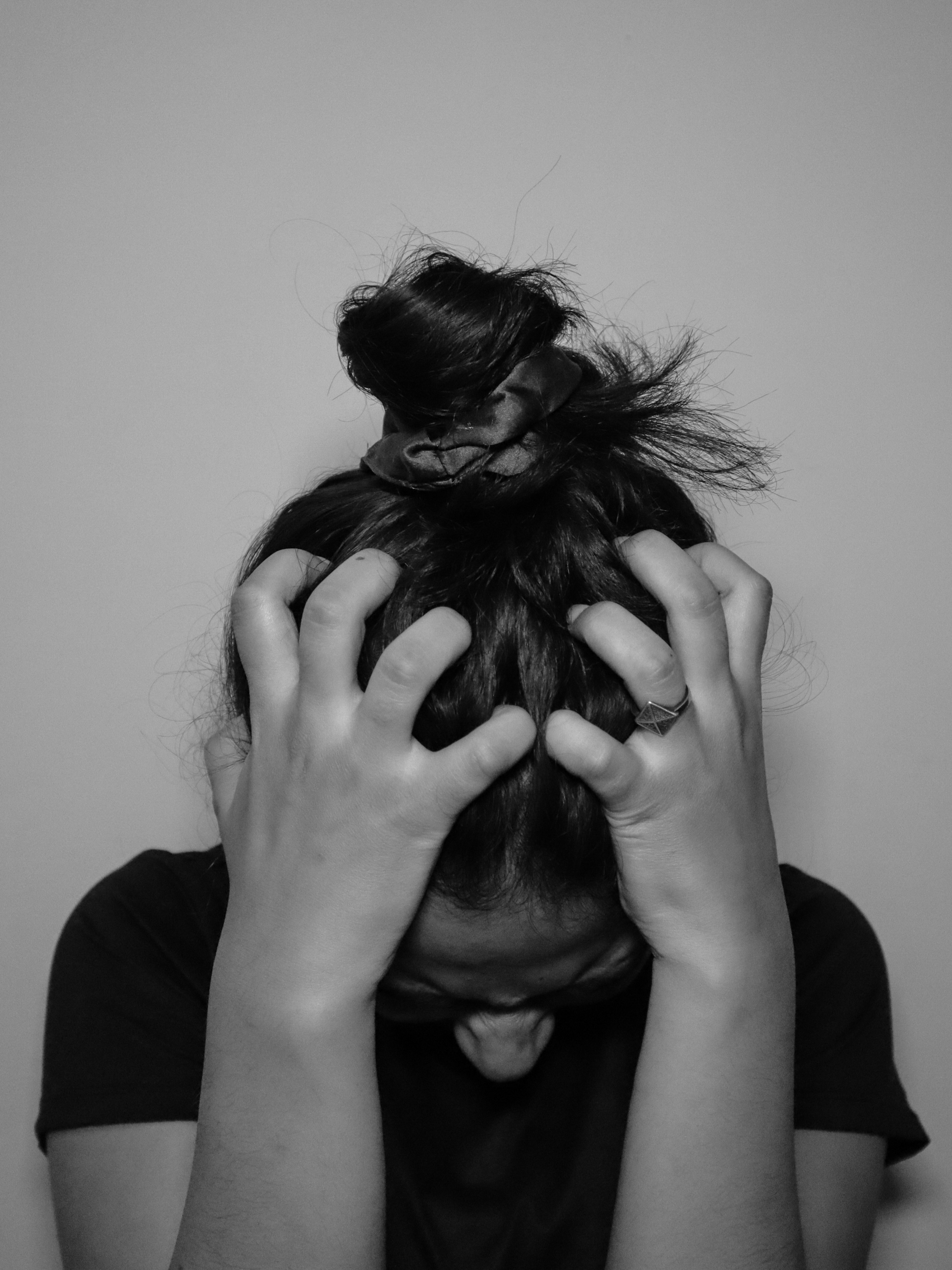 Person experiencing anxiety with hands on head, illustrating the overwhelming feeling of anxious thoughts